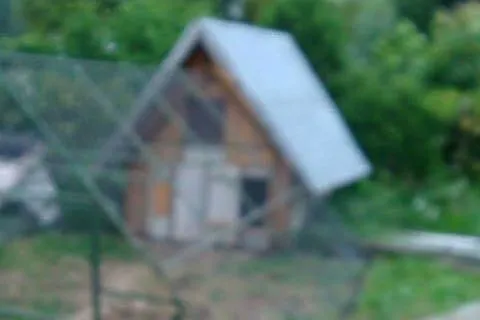 kurnik drewniany z klatką metalową.